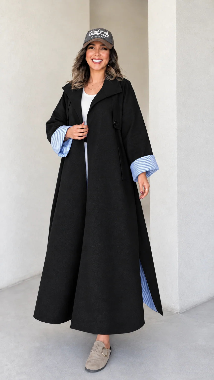 Full-length studio shot of woman wearing black maxi trench duster coat