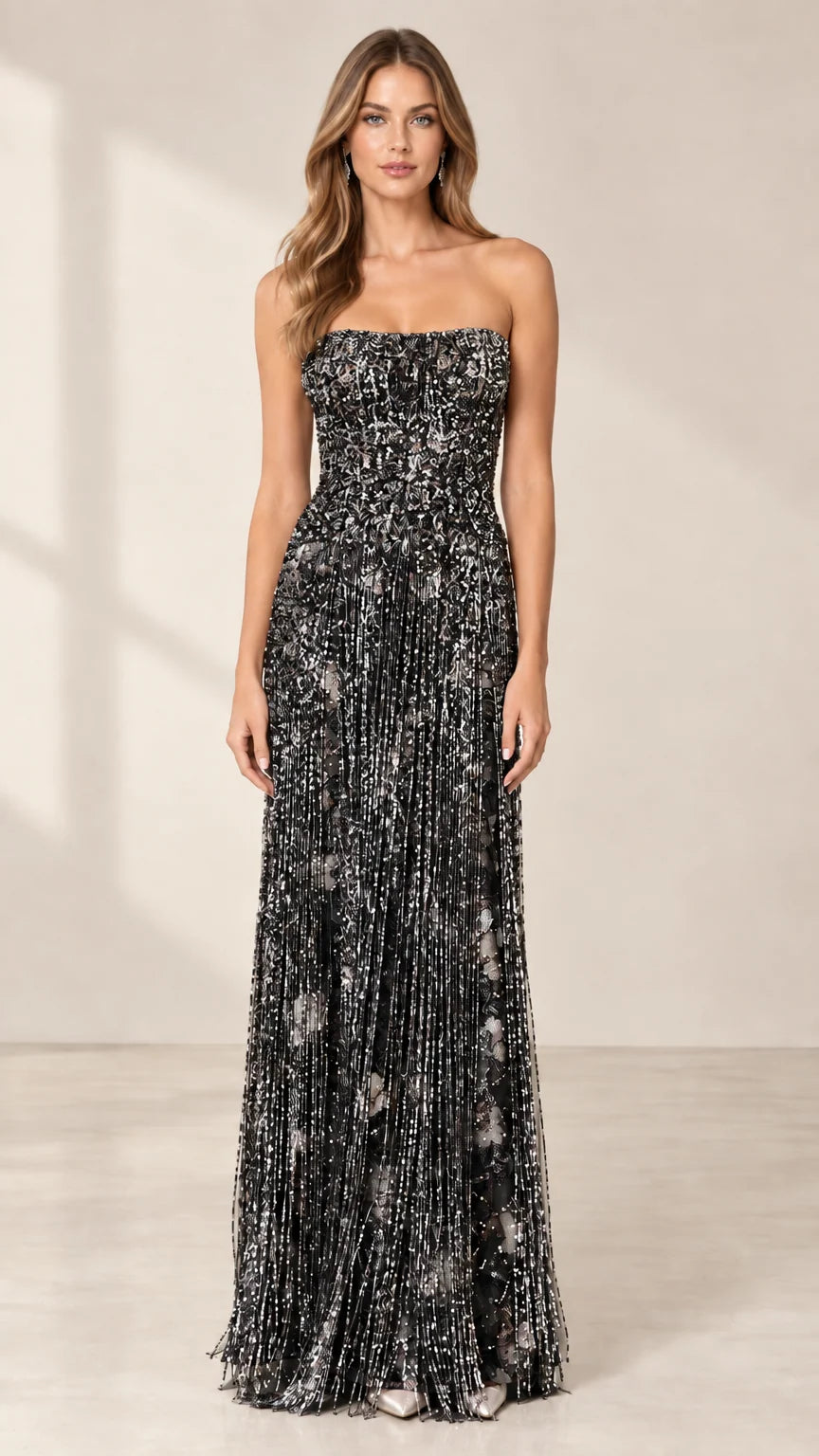 Front view of model wearing black strapless beaded fringe formal dress