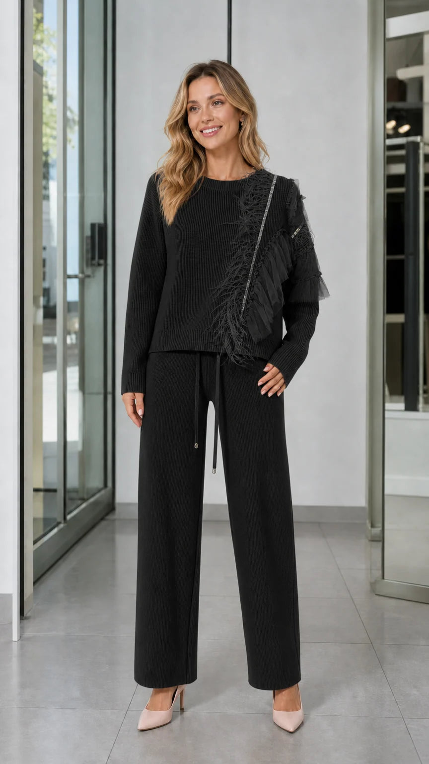 Full-length front view of woman wearing Black feather trim knit sweater and wide-leg pants set