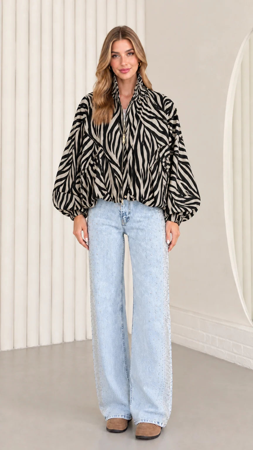 Model wearing classic black and cream zebra print balloon sleeve jacket with wide-leg jeans