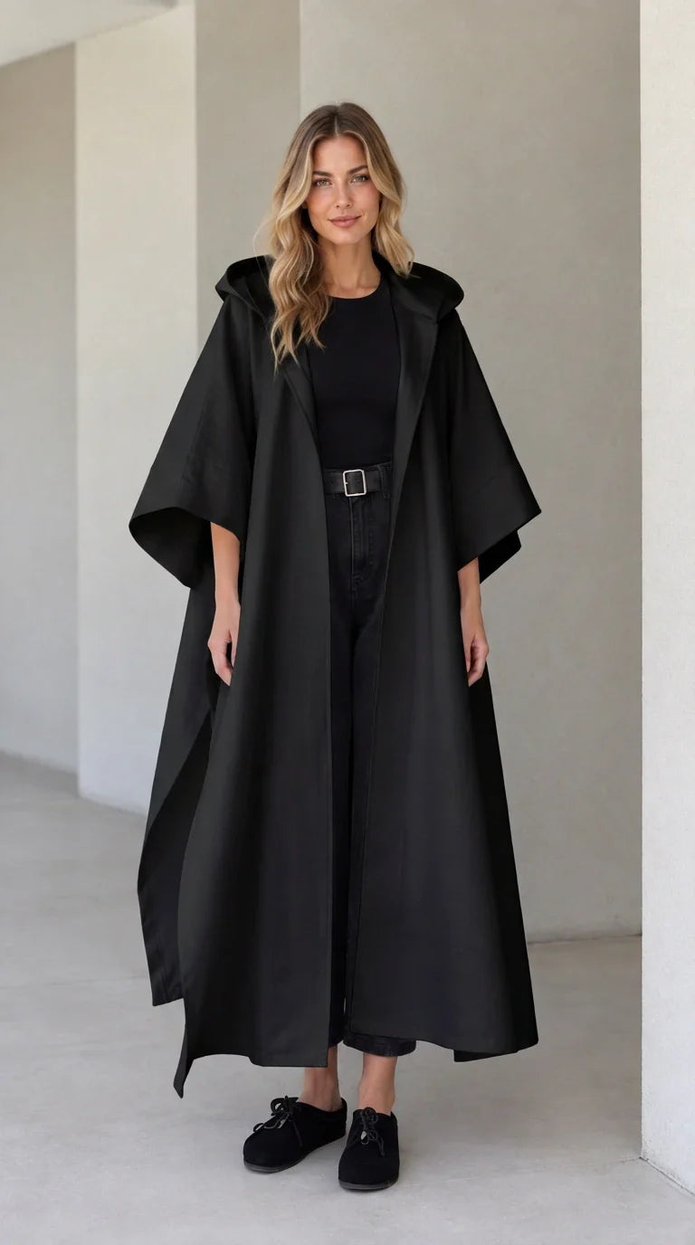 Model wearing black hooded maxi canvas cape coat with open front