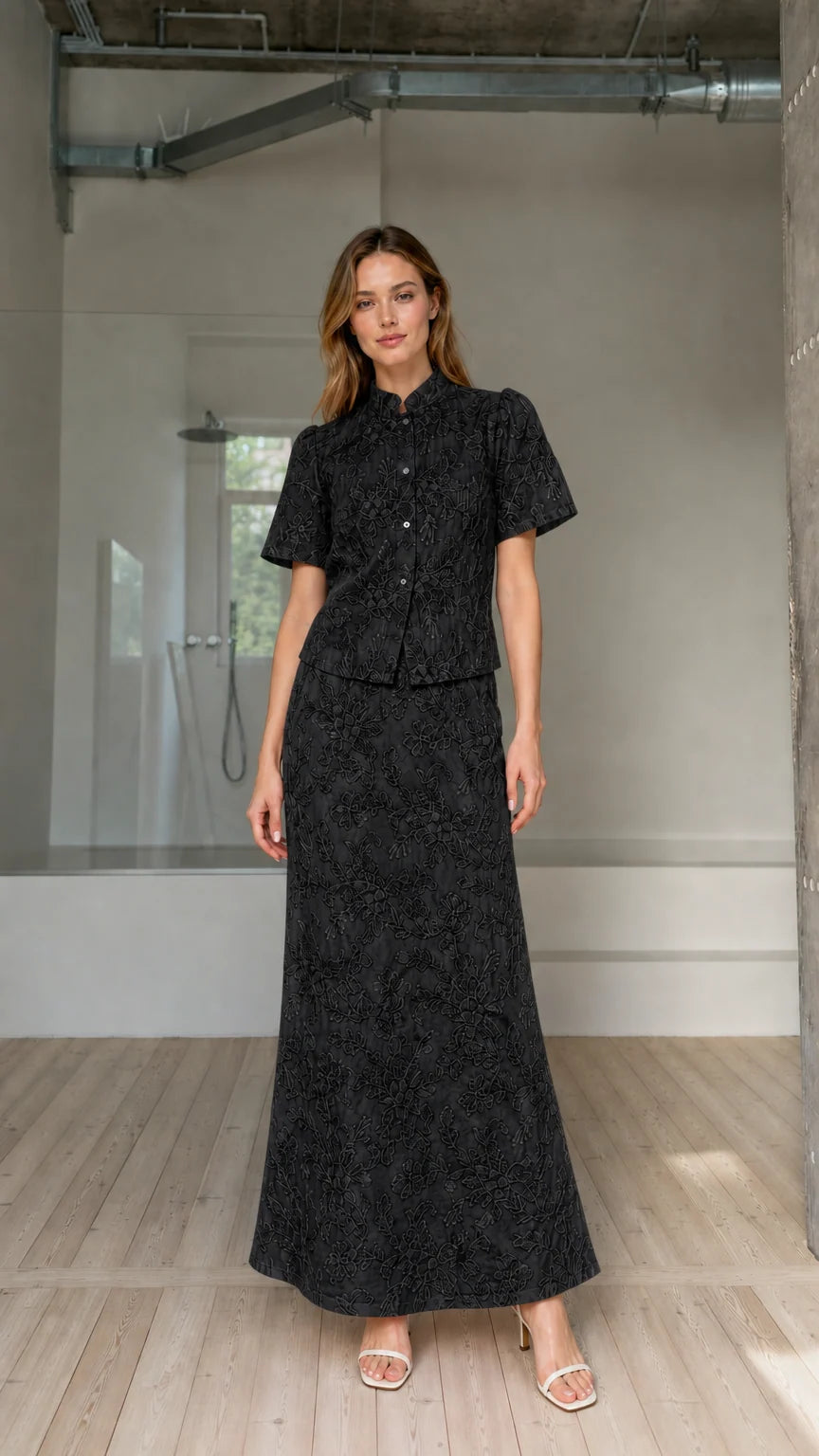 Model wearing black floral embroidered short-sleeve top and maxi skirt matching set