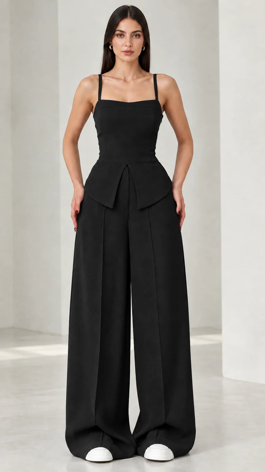 Full front view of model wearing black square neck peplum wide leg jumpsuit