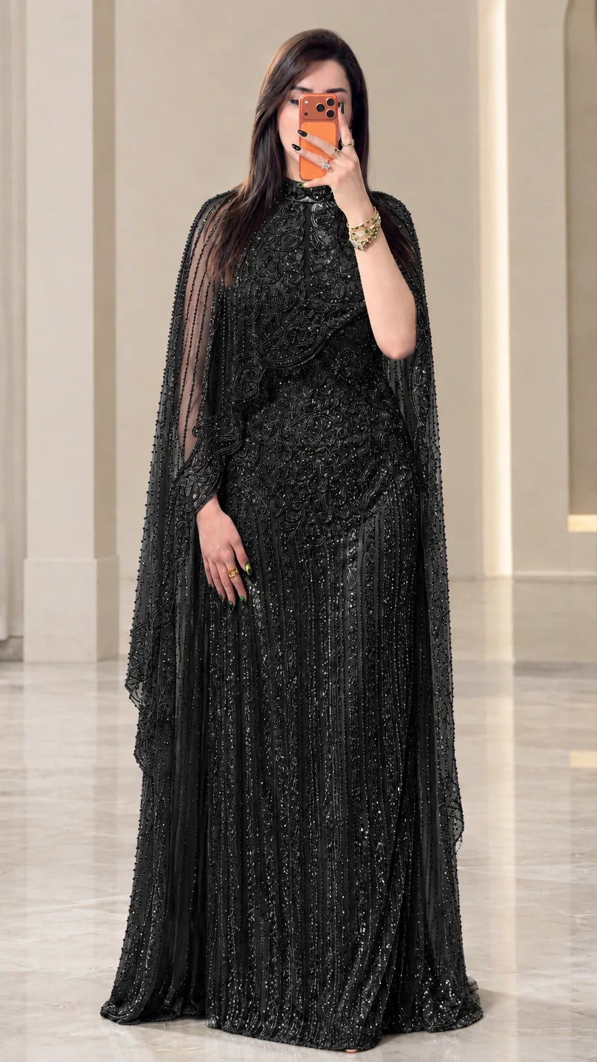 Full-length view of black beaded cape evening gown with sparkling embellishments