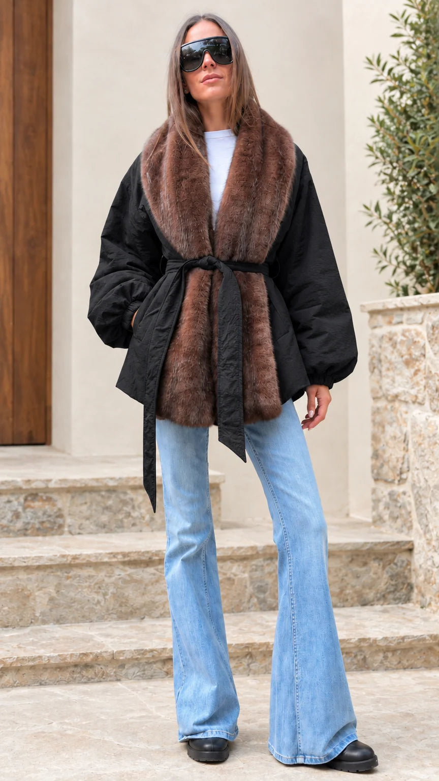 Woman modeling black belted jacket with contrasting brown faux fur trim