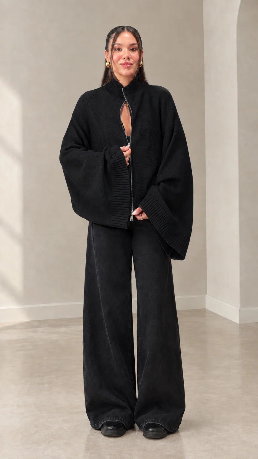 Woman wearing black zip-front batwing sleeve knit cardigan