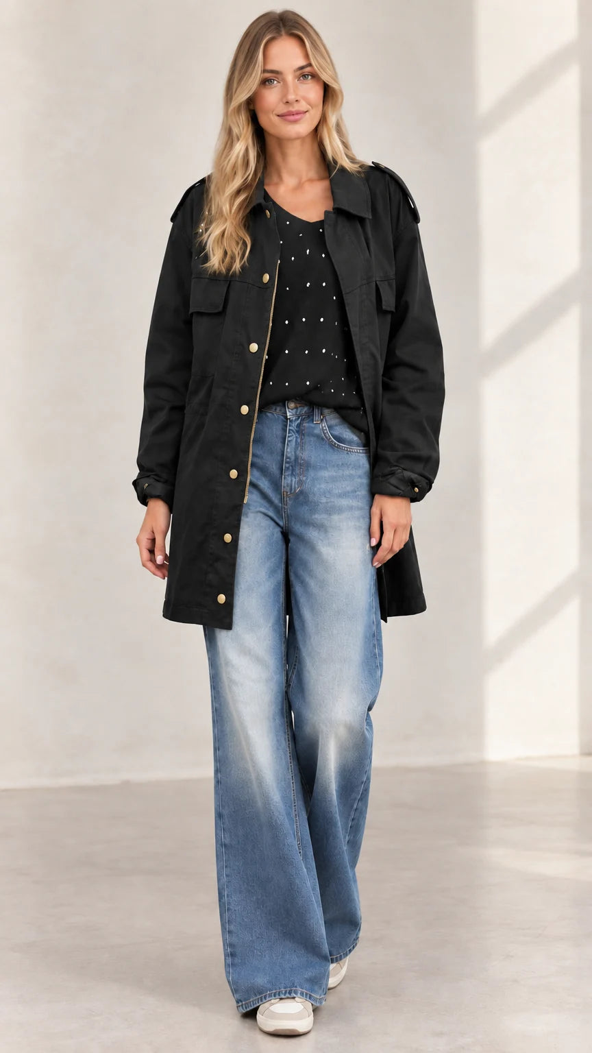 Full front view of women's black mid-length utility jacket with jeans