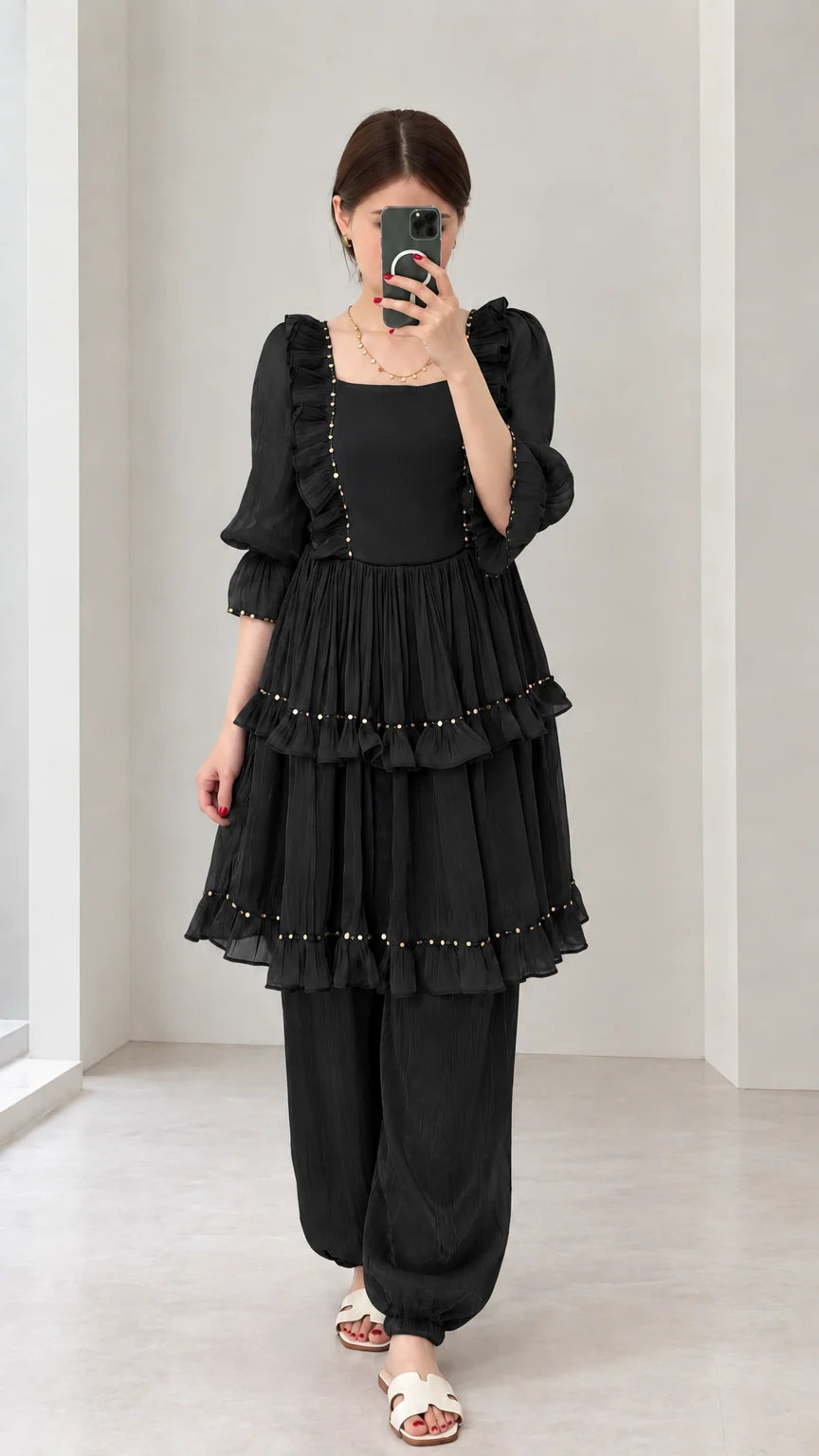 Front view of woman wearing Black tiered ruffle tunic and gathered-ankle pant set