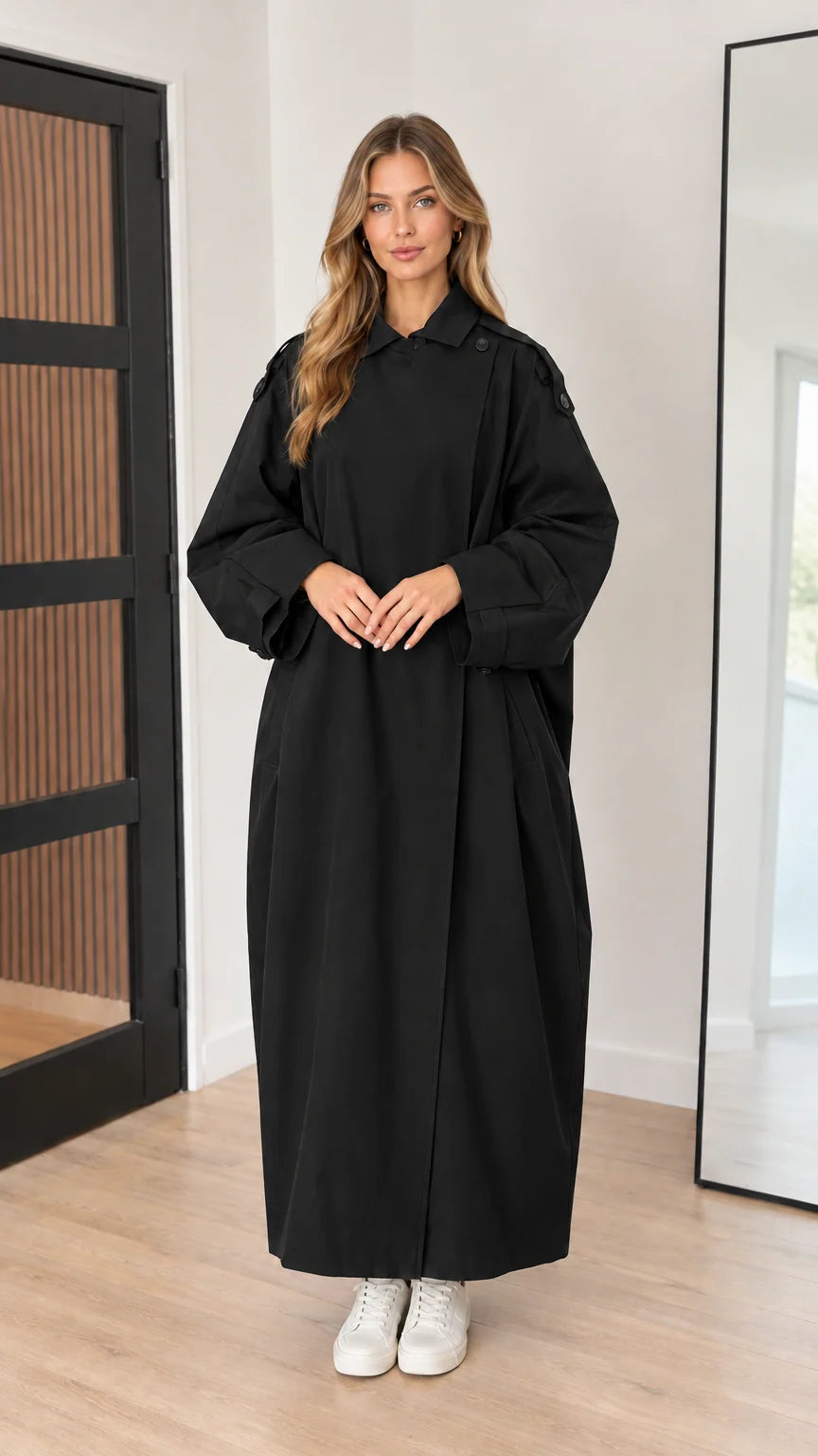 Full-length front view of black oversized maxi trench coat on model