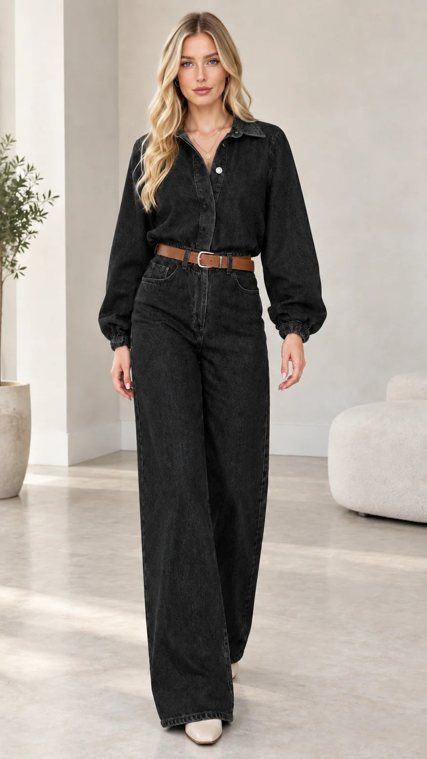 Model wearing washed black wide-leg denim jumpsuit with brown belt
