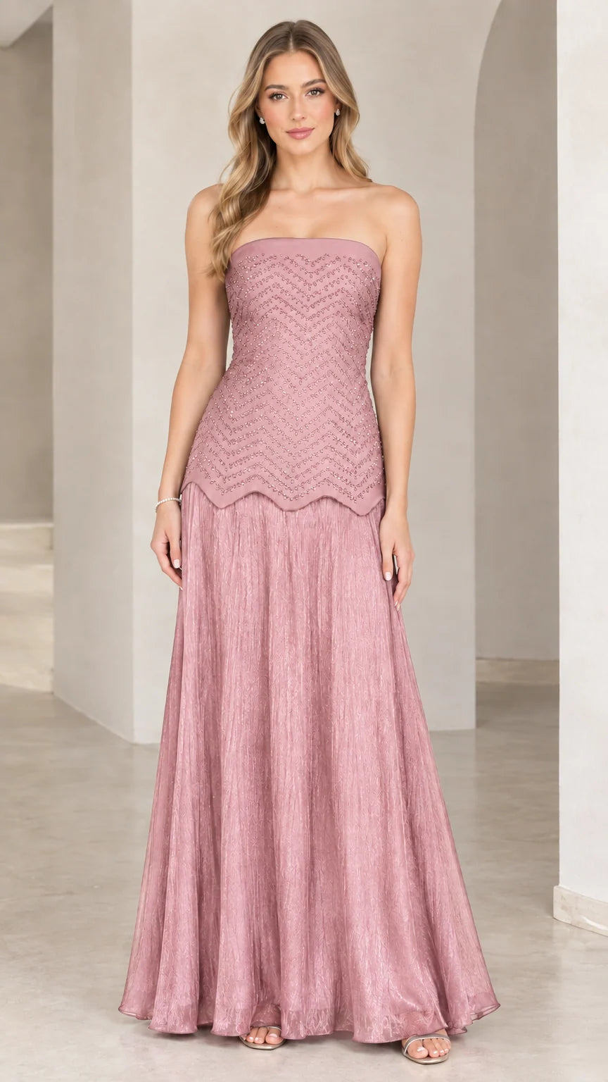 Full-length view of model in dusty rose pink strapless beaded evening gown