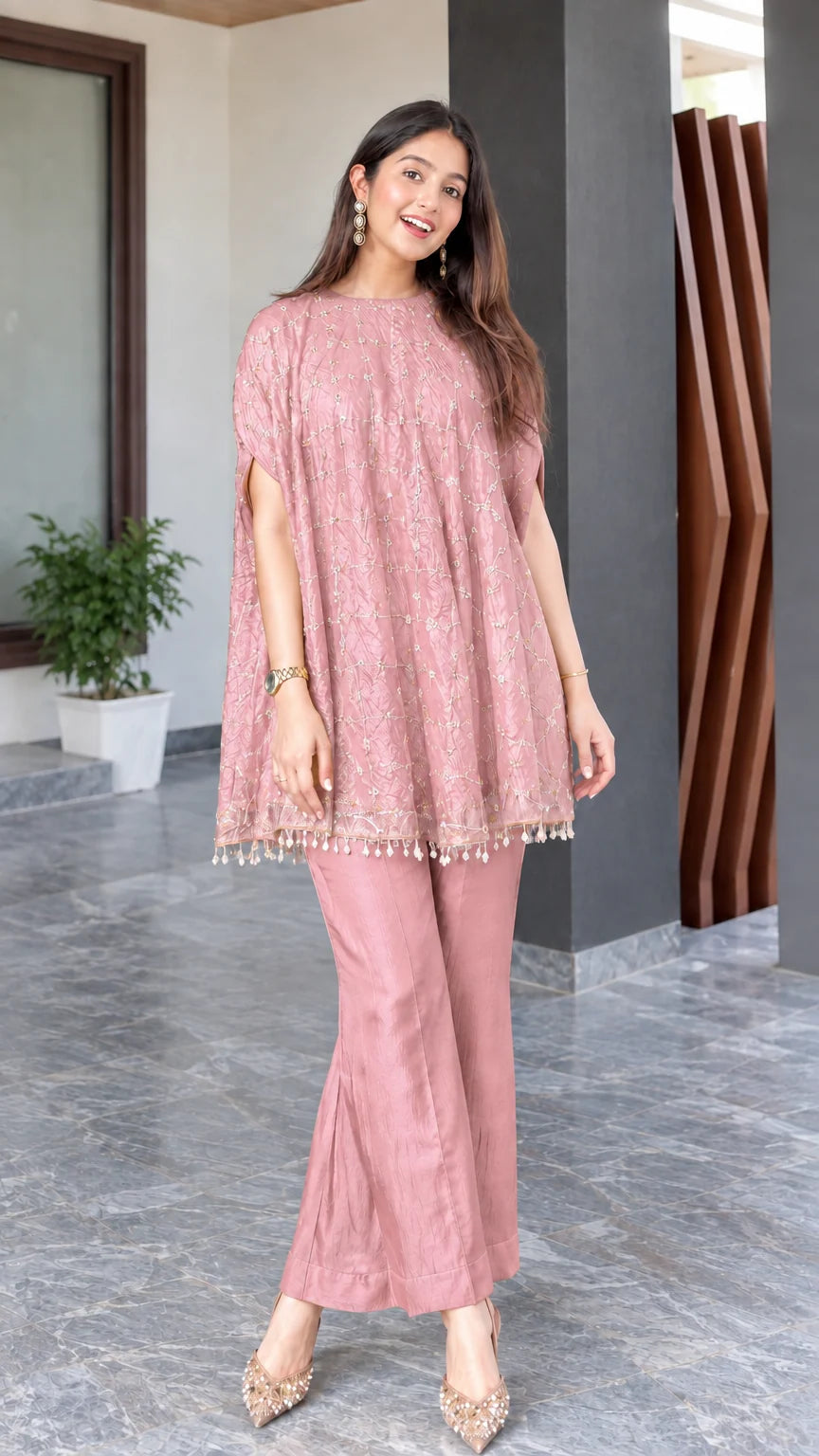 Model wearing dusty pink embroidered cape tunic and matching flared trousers