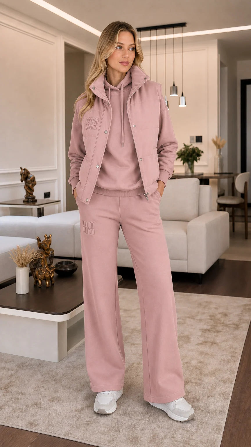 Model wearing dusty pink 3-piece puffer vest, hoodie, and wide-leg sweatpants set