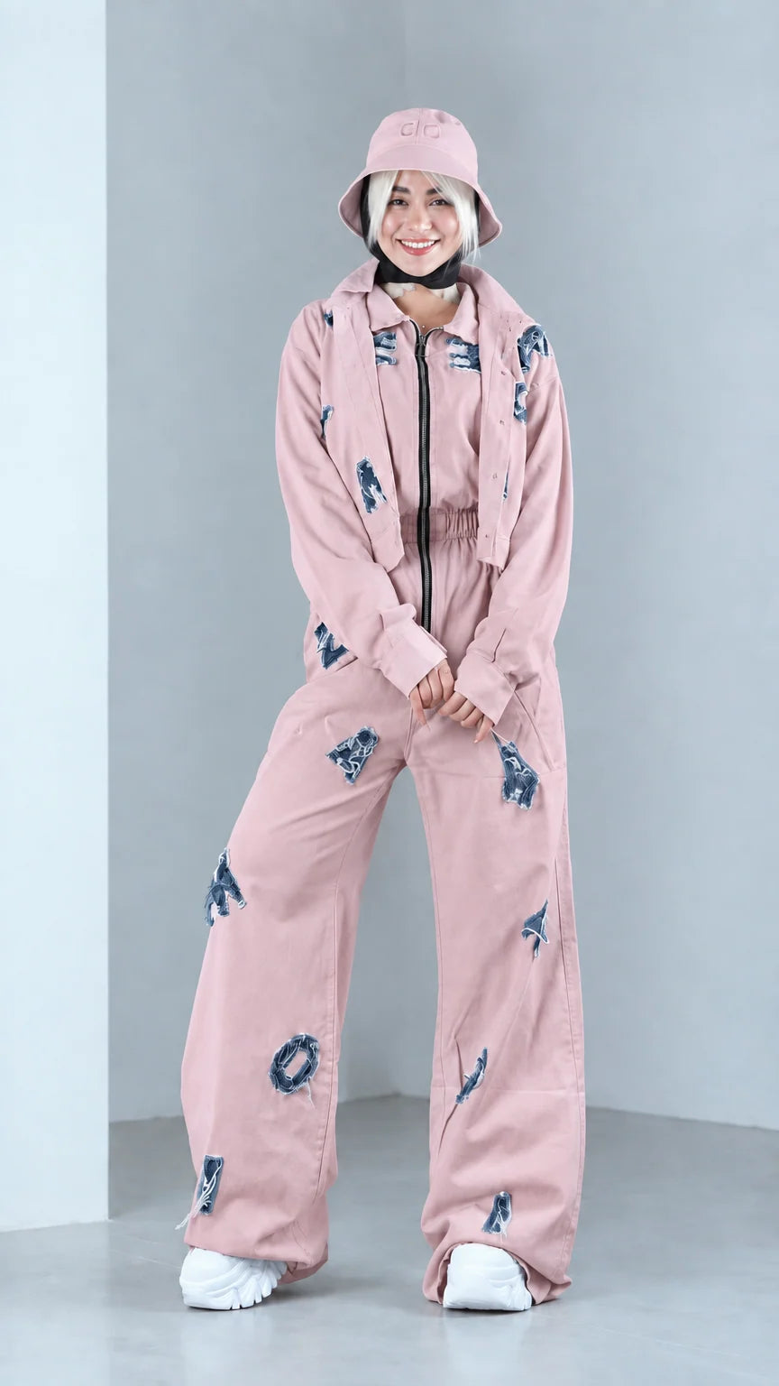Full front view of model in dusty pink distressed two-piece jacket and pants set