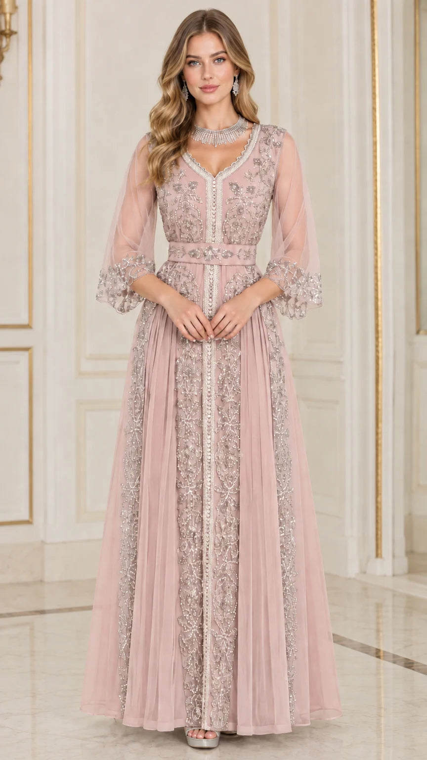 Front full-length view of woman in dusty pink embroidered beaded formal maxi dress