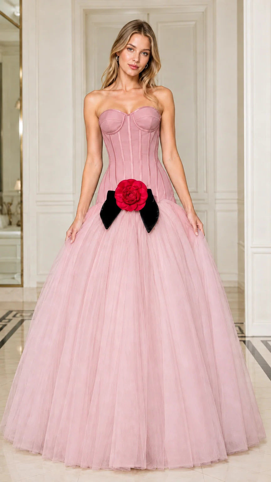 Model wearing blush pink strapless corset ball gown with red floral waist detail