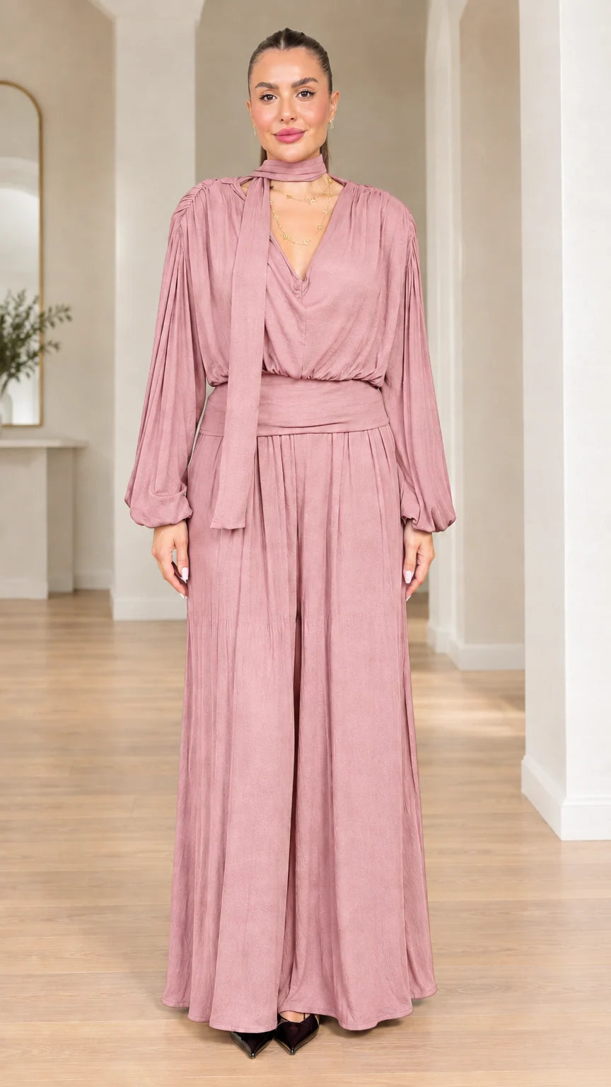 Model wearing dusty rose long-sleeve wide-leg evening jumpsuit