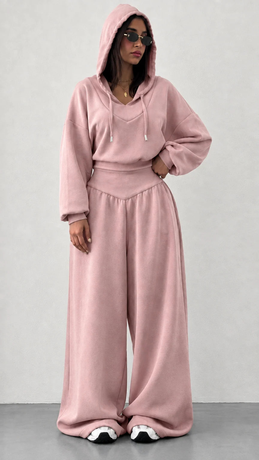 Woman wearing dusty pink 2-piece hooded sweatshirt and wide leg pants set