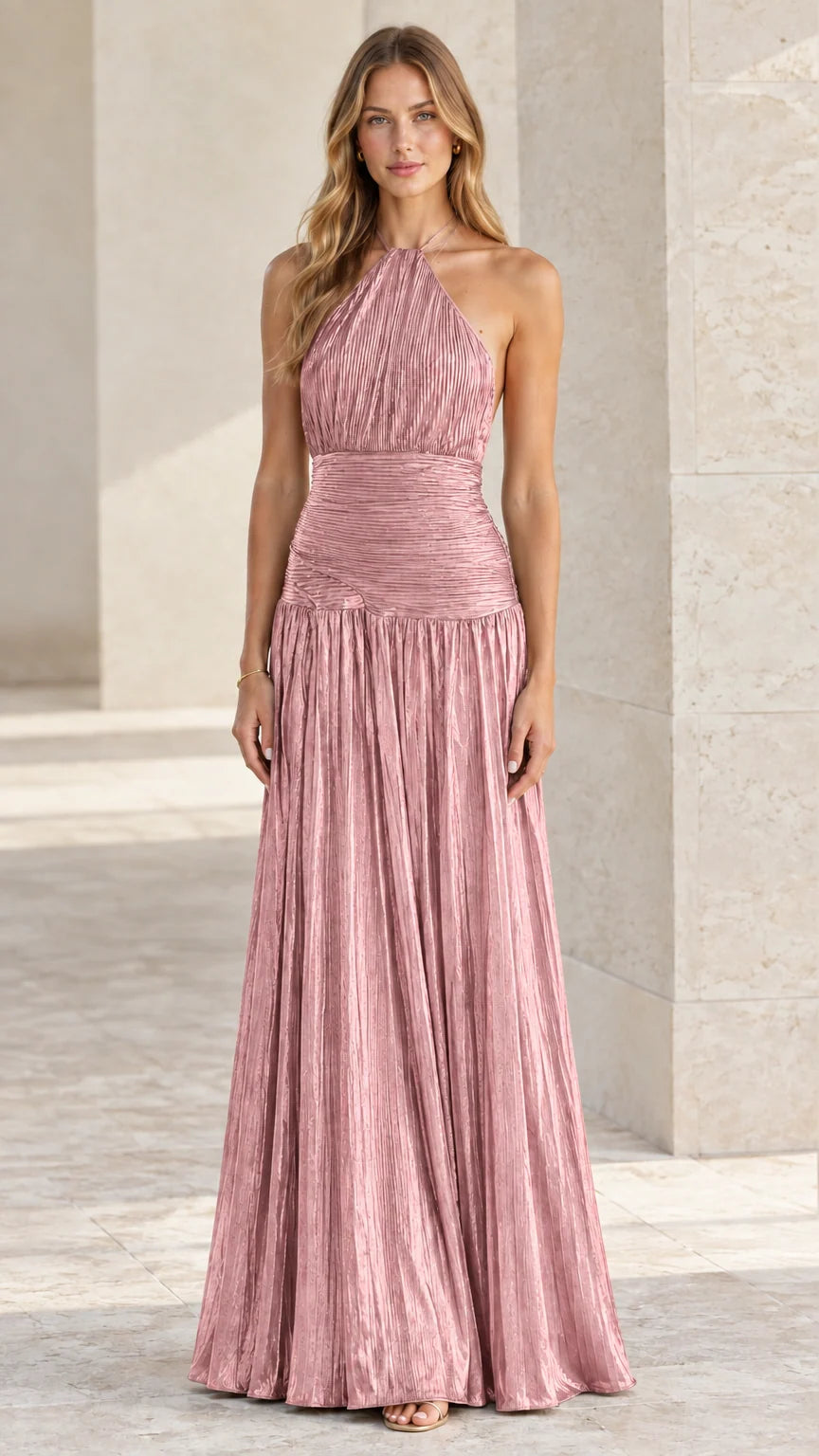 Model wearing blush pink plisse pleated halter backless formal gown