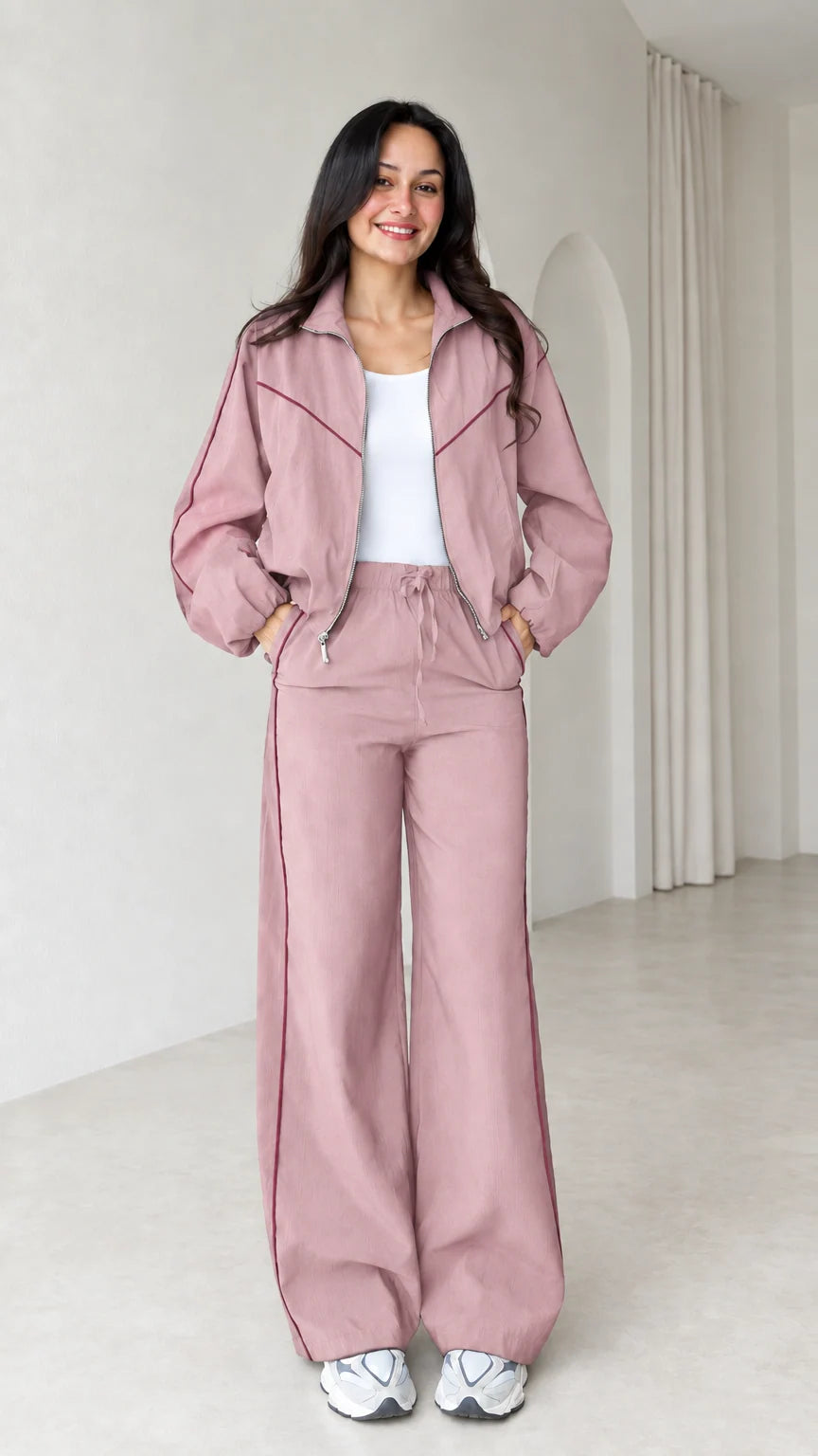 Model wearing dusty pink zip track jacket and wide leg pants set