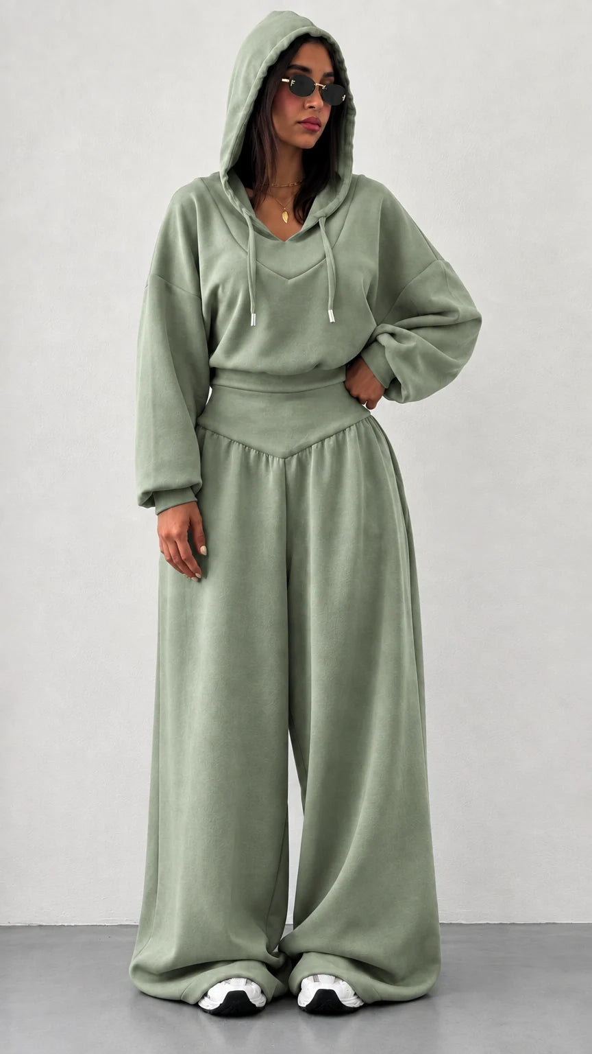 Woman wearing sage green 2-piece hooded sweatshirt and wide leg pants set