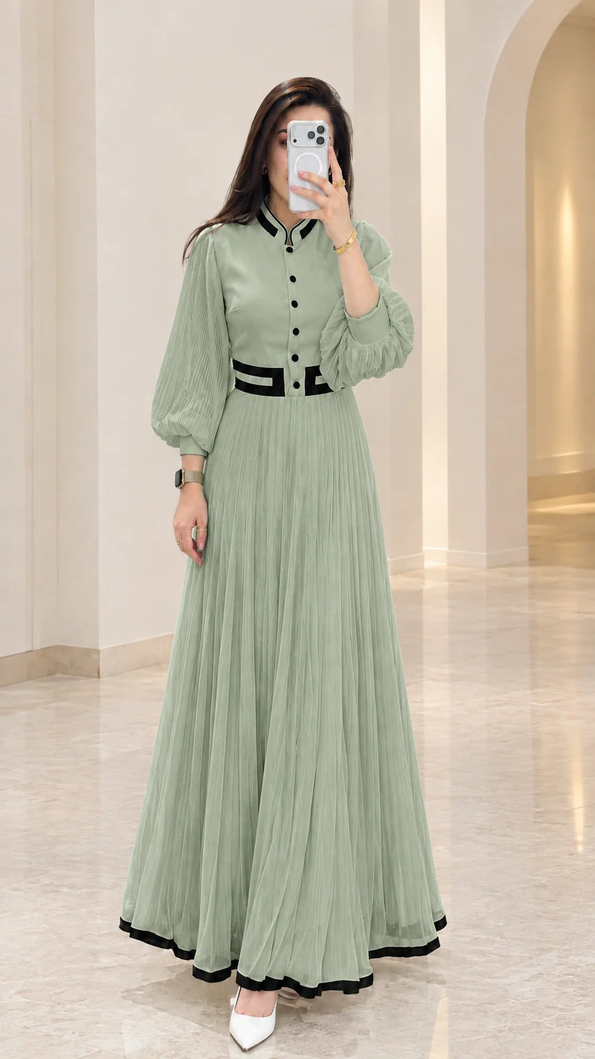 Sage green pleated maxi dress with black contrast trim and sheer sleeves