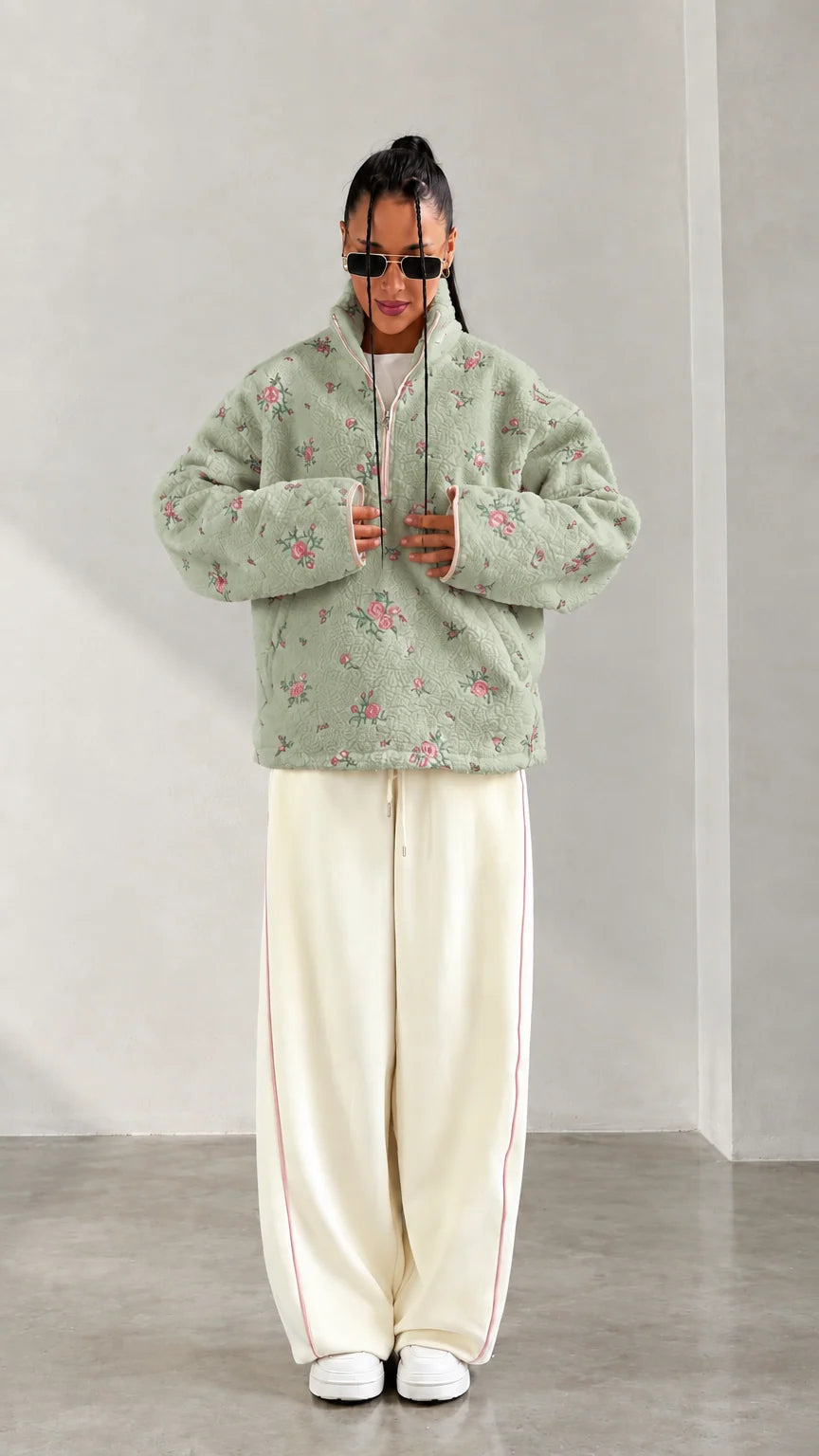 Front view of model wearing sage green floral print half-zip fleece pullover