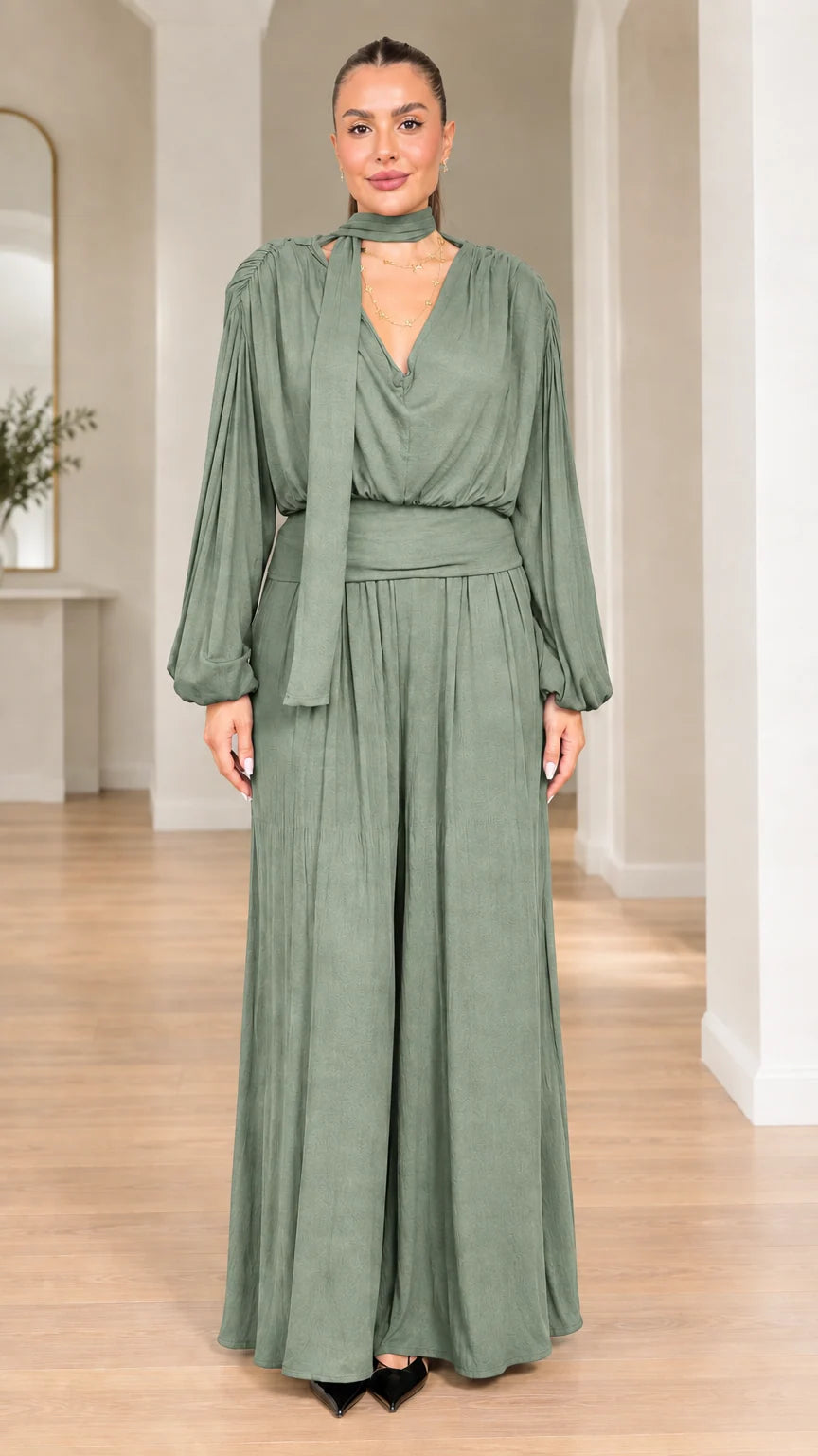 Model wearing sage green long-sleeve scarf neck wide-leg jumpsuit