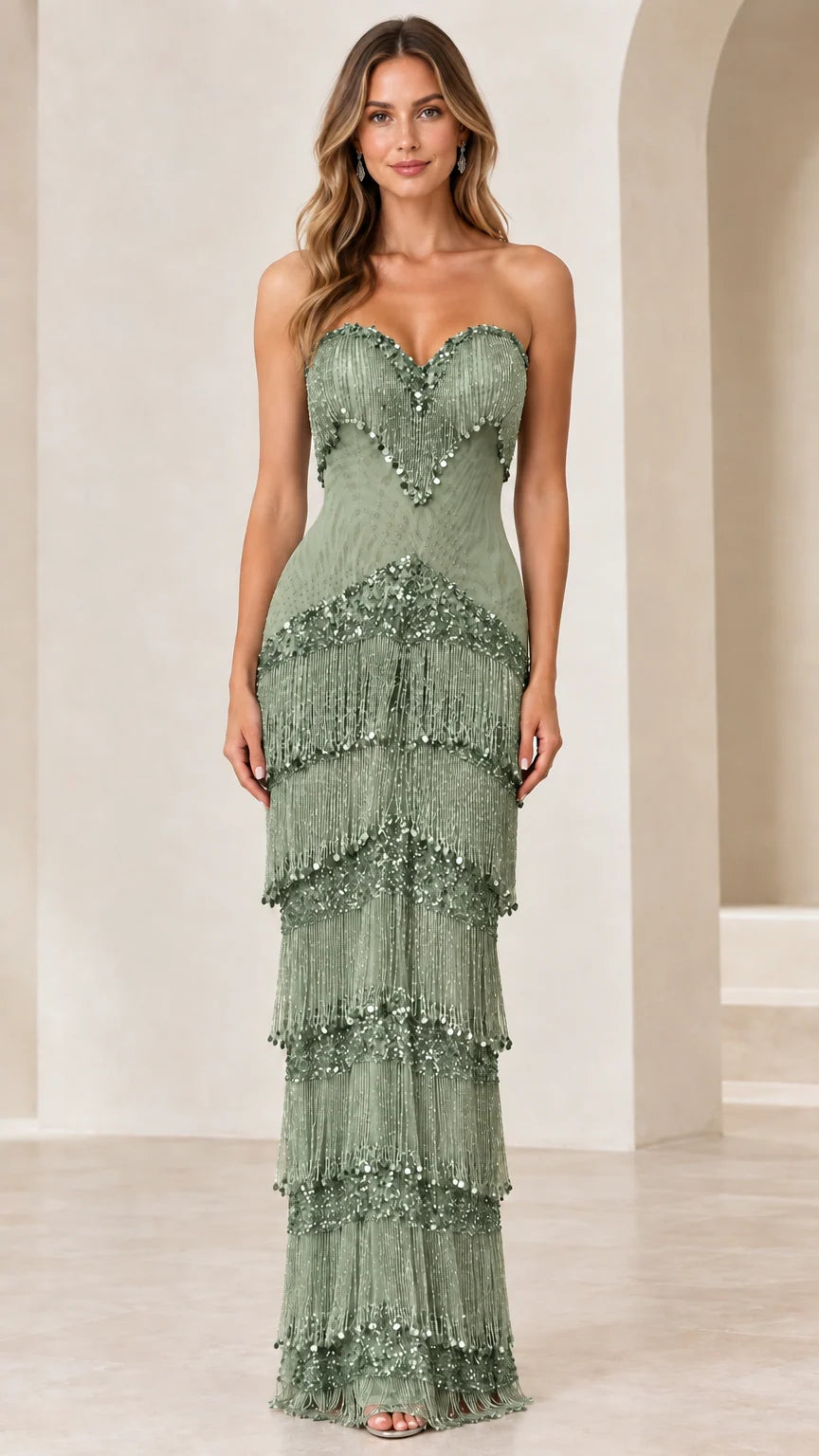 Front view of woman wearing sage green strapless tiered fringe evening gown