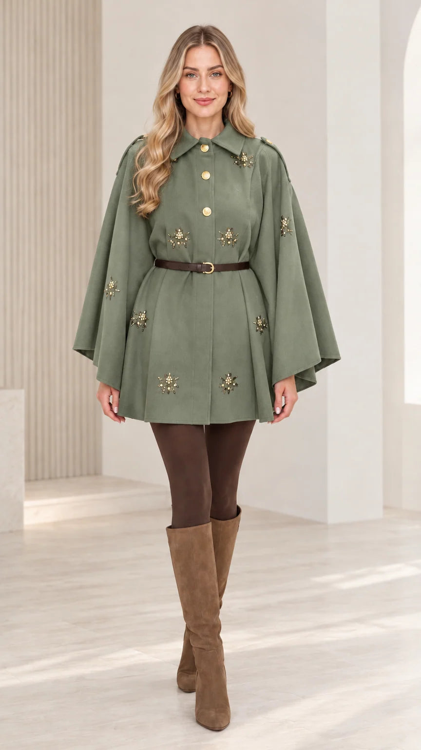 Front view of woman wearing sage green embellished button-front belted cape coat