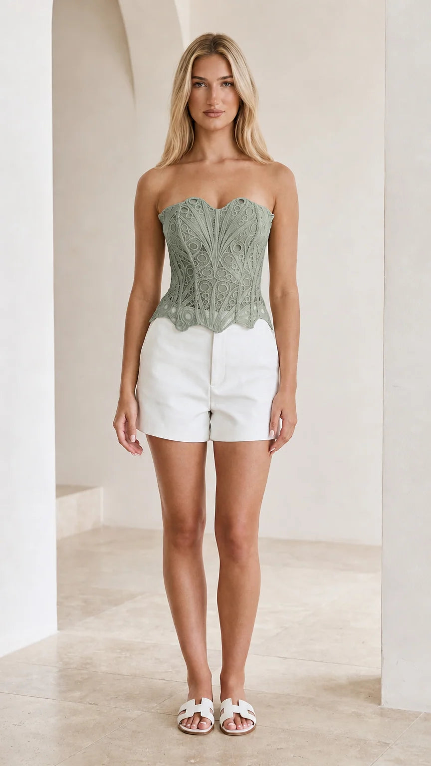 Front view of woman wearing sage green strapless crochet lace corset top