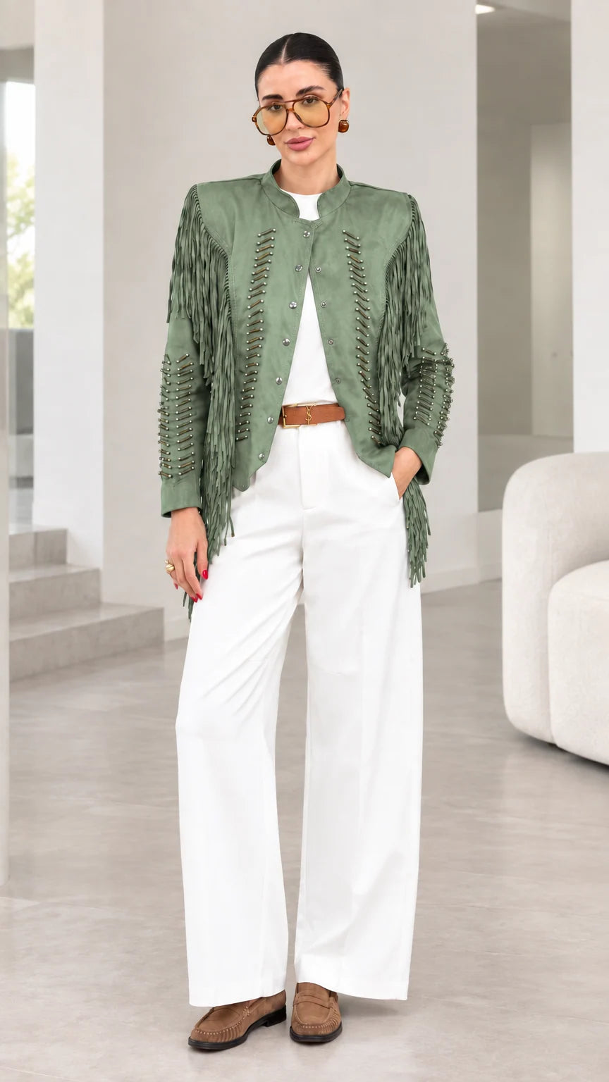 Model wearing sage green faux suede fringe jacket with white pants