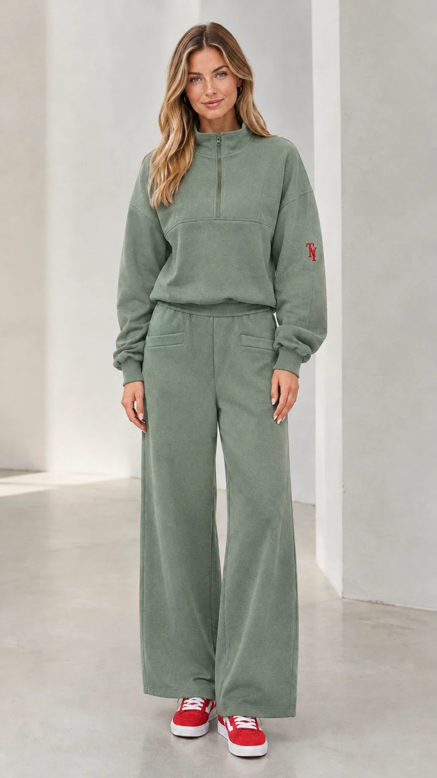 Front view of woman wearing sage green half-zip pullover and wide-leg lounge set