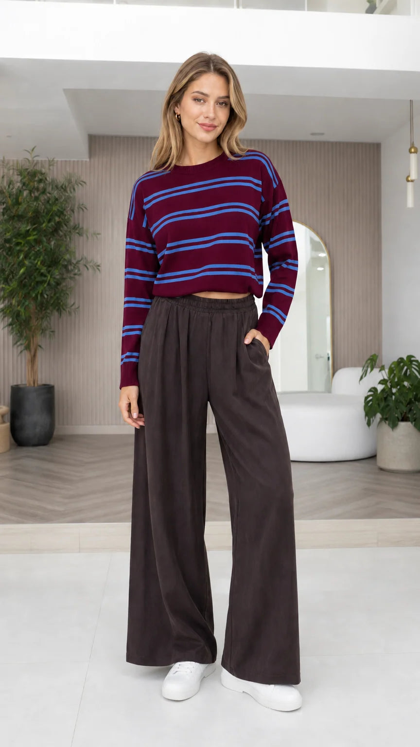 Model wearing burgundy and blue striped crewneck knit top with wide-leg pants