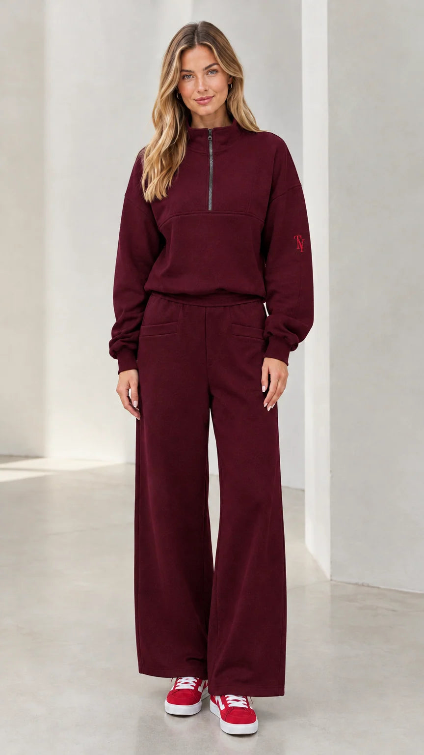 Front view of woman wearing burgundy half-zip pullover and wide-leg lounge set