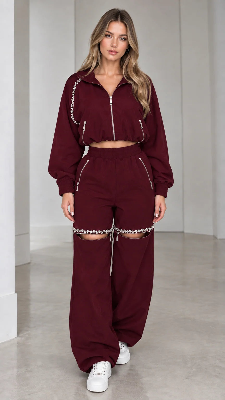 Model wearing burgundy wine cropped zip jacket and rhinestone cut-out wide leg pants set