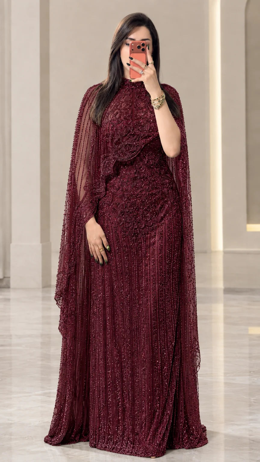 Full-length view of burgundy red embellished cape formal evening dress