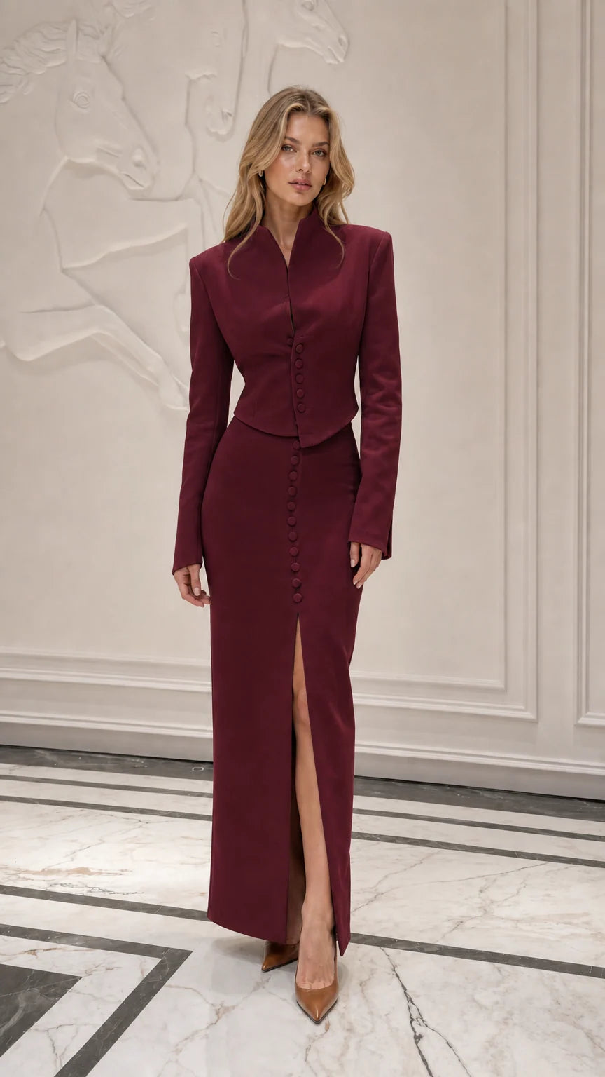 Model wearing burgundy formal two-piece jacket and skirt set