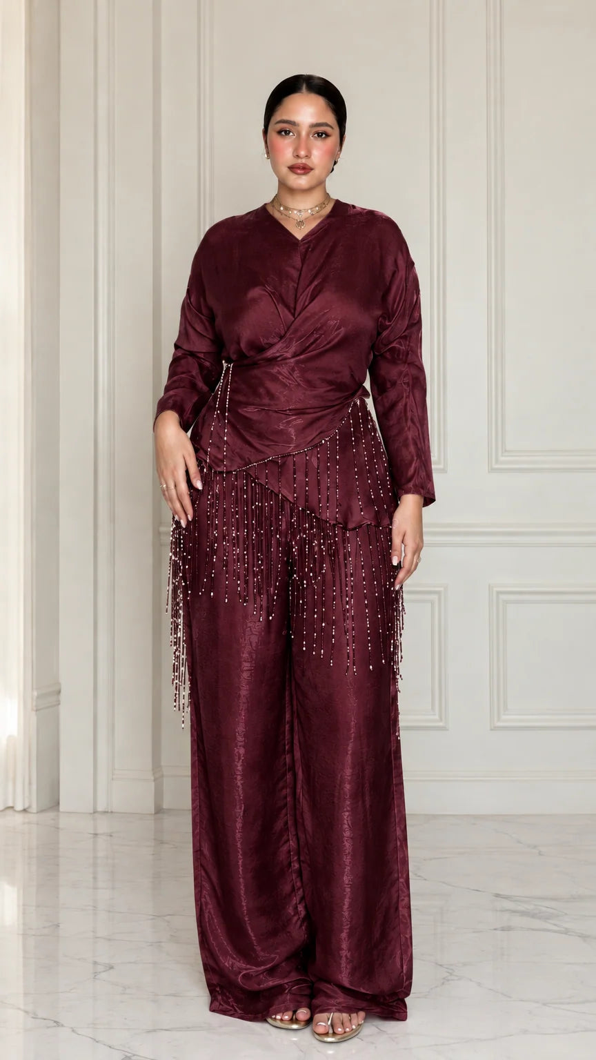 Full-length view of model wearing Burgundy satin draped two-piece set with beaded trim