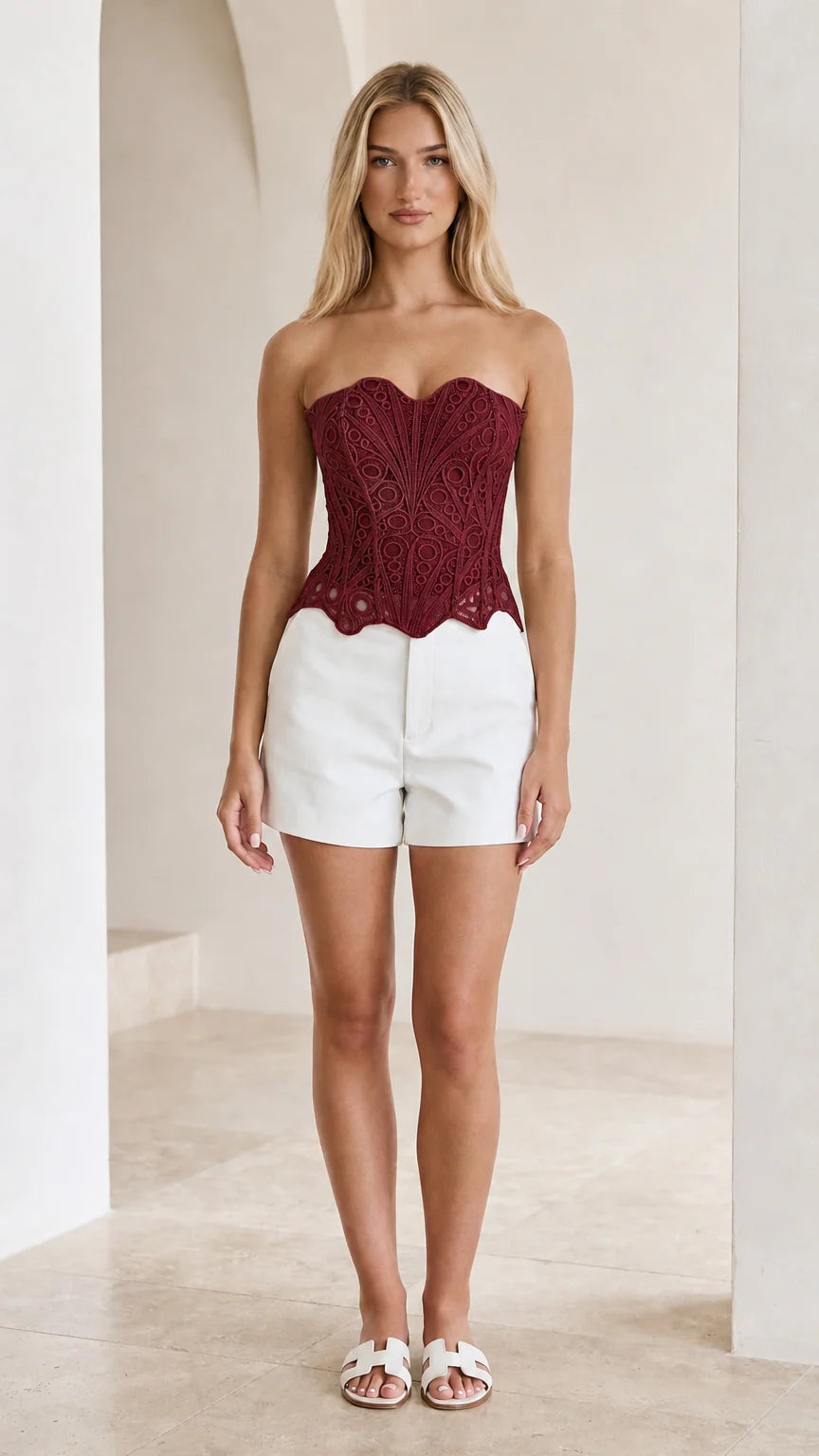Front view of woman wearing burgundy strapless crochet lace corset top