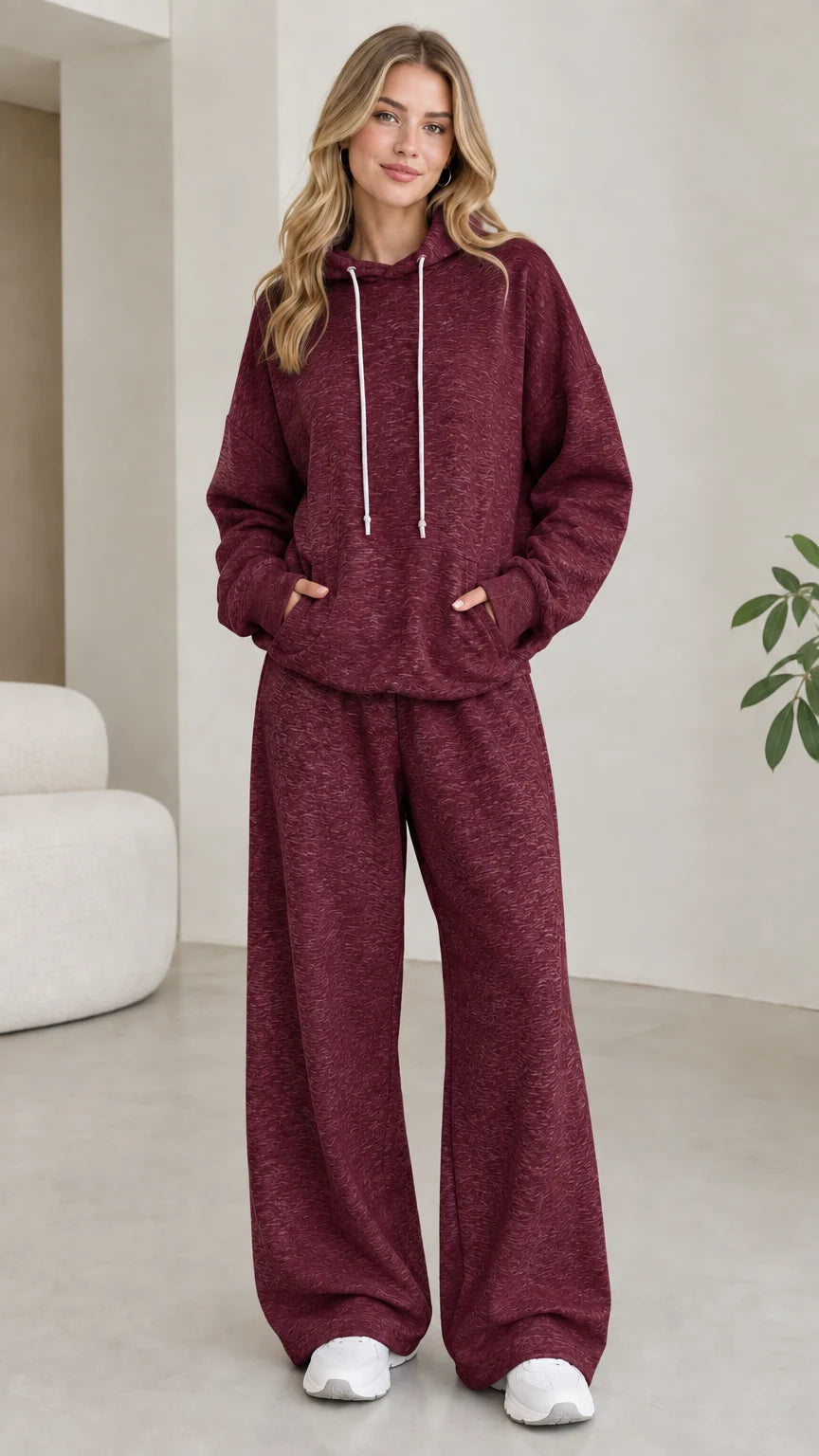Model wearing burgundy red 2-piece drawstring hoodie and wide leg sweatpants set