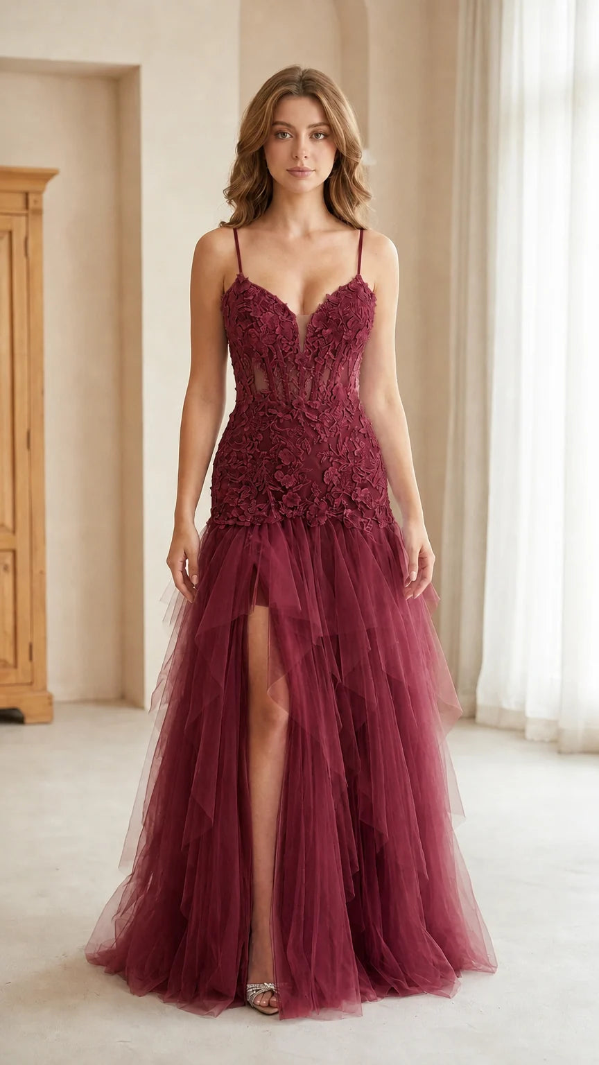 Front view of model wearing burgundy wine corset tulle gown with thigh slit