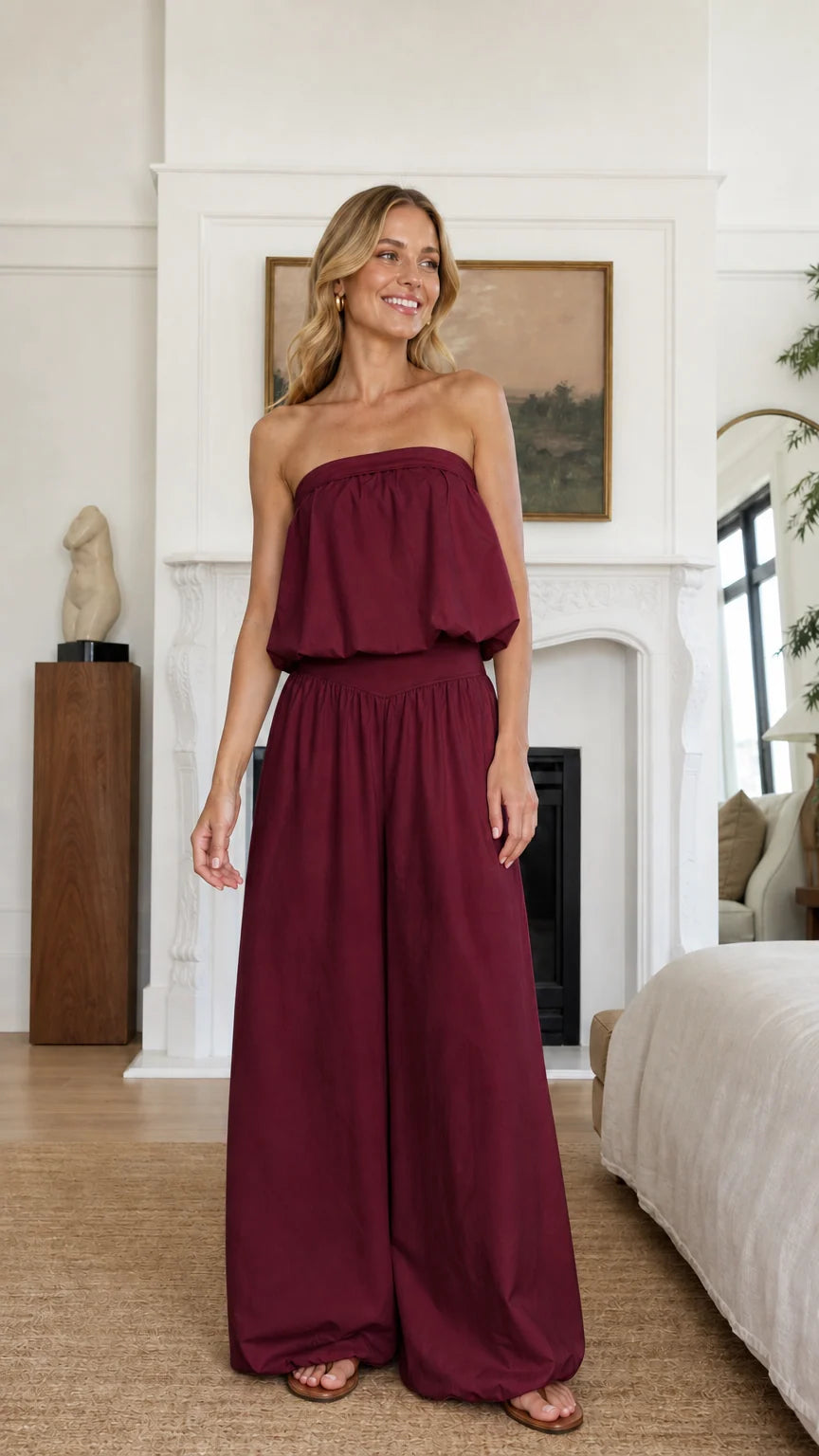 Model wearing burgundy strapless ruffle crop top and wide leg pants set