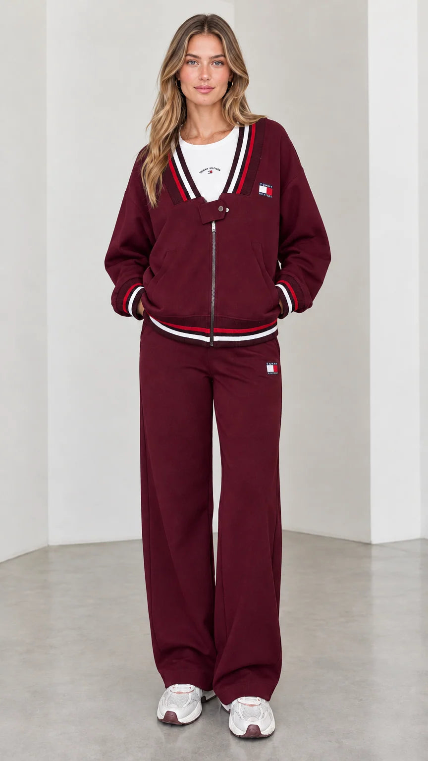 Front view of model wearing burgundy varsity striped tracksuit set