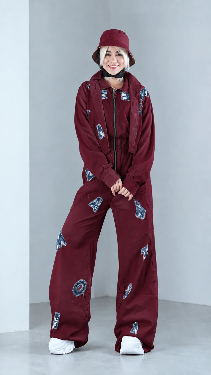 Full front view of model in burgundy distressed two-piece jacket and pants set