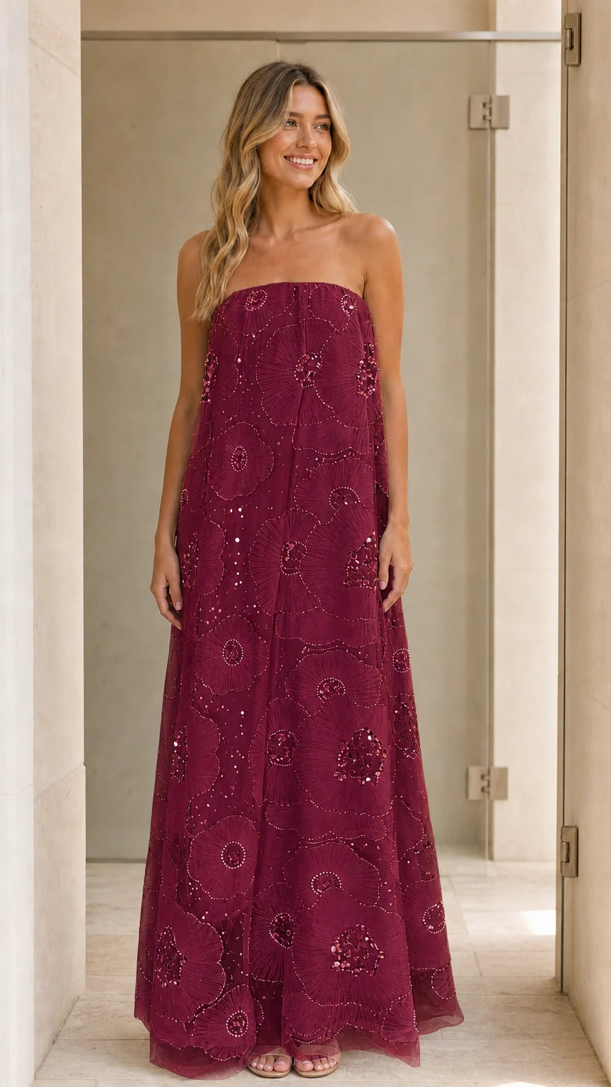 Model wearing burgundy strapless sequin floral maxi dress