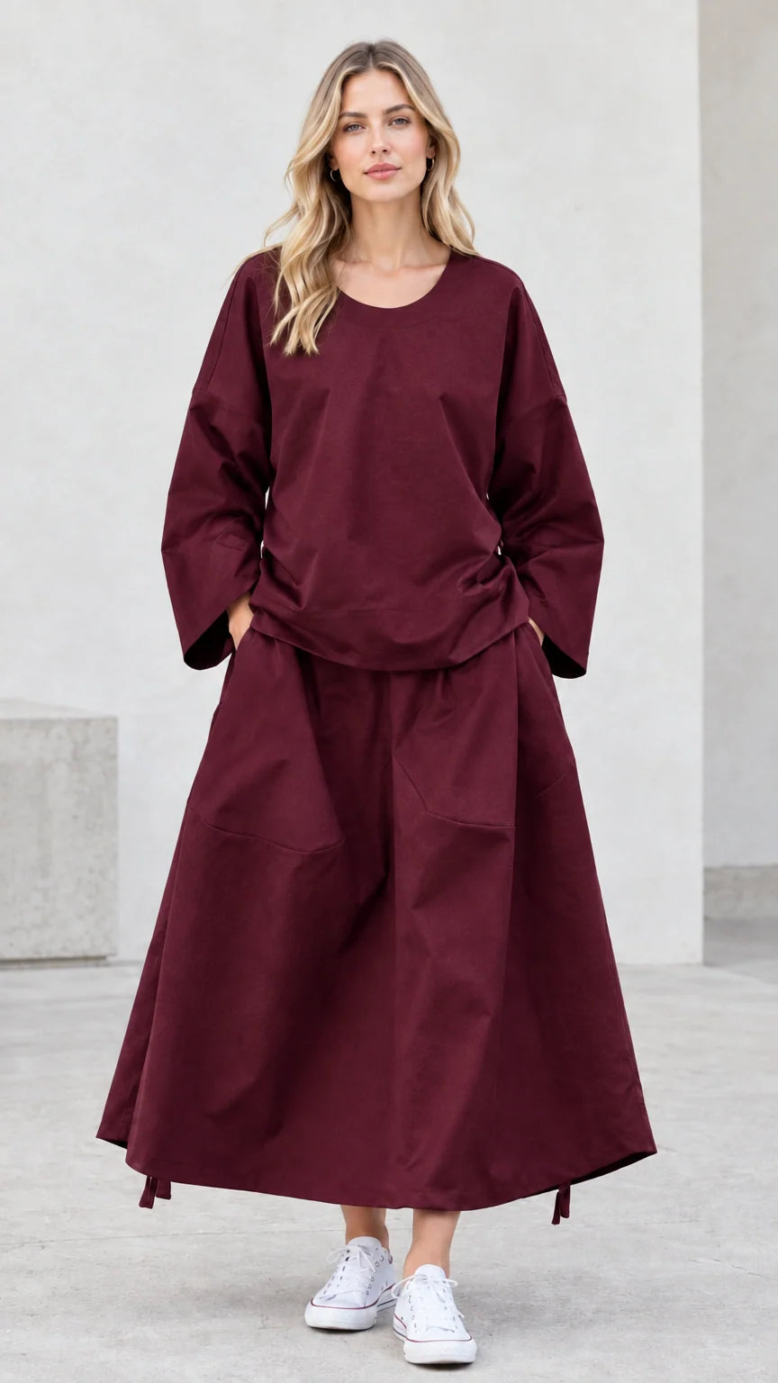 Front view of model wearing rich burgundy matching top and maxi skirt set