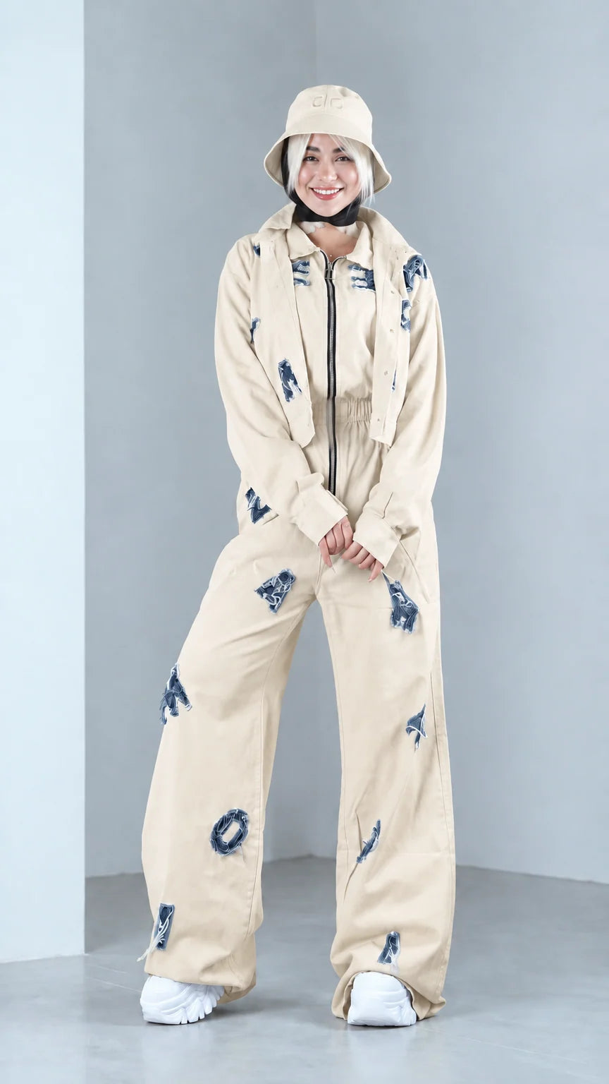 Full front view of model in beige distressed two-piece jacket and pants set