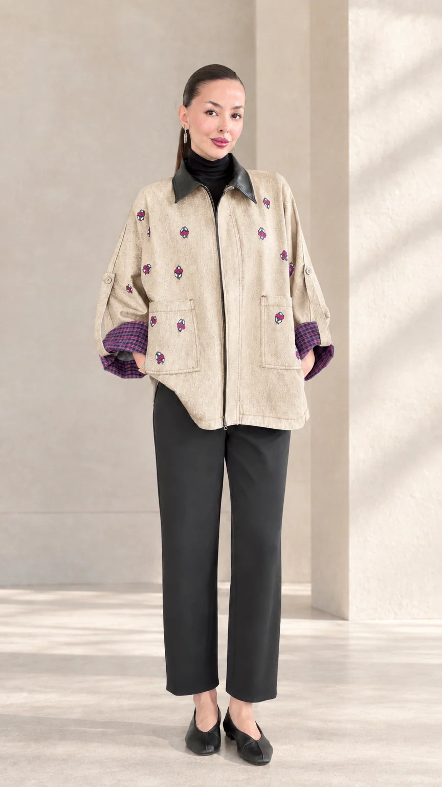 Beige neutral embroidered zip-up jacket styled with black trousers