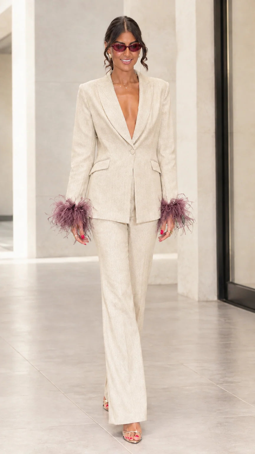 Front view of woman wearing champagne cream tailored suit set with mauve feather cuffs